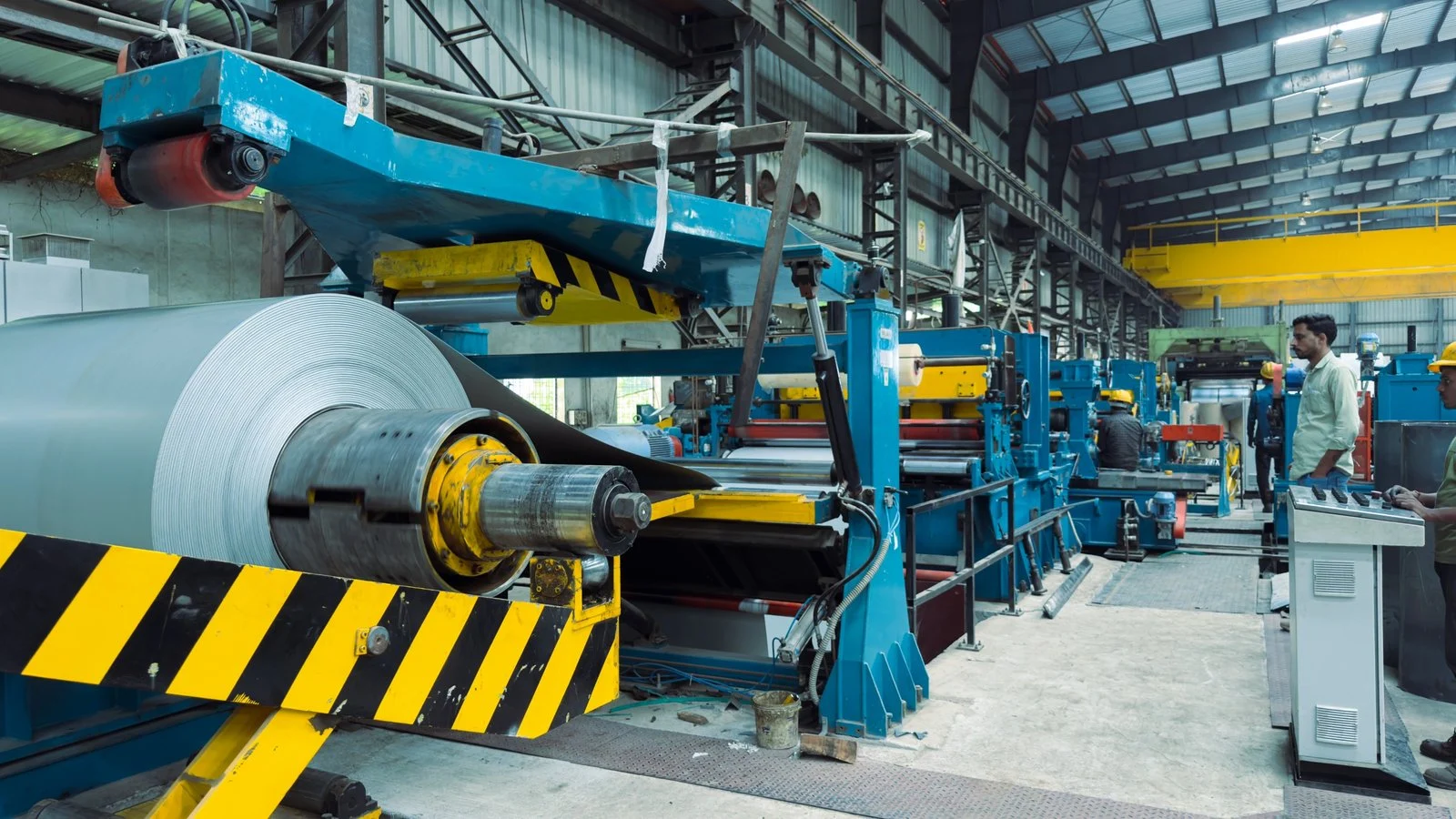 Steel coil mounted on blue processing machinery