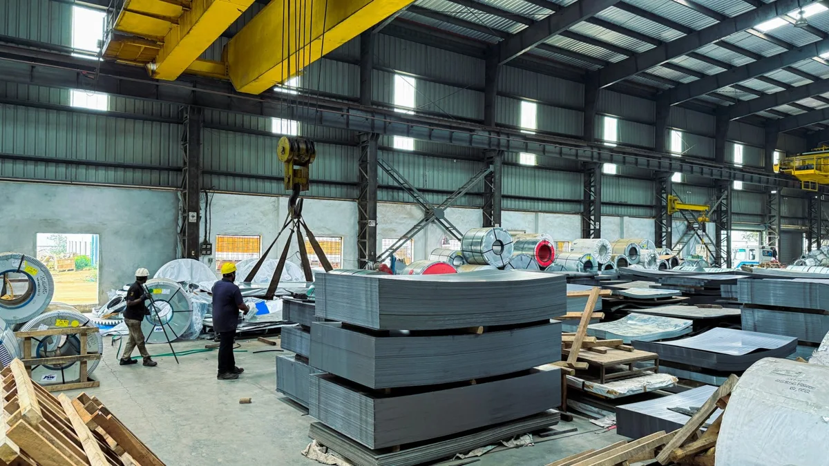 Steel sheets being handled beneath an overhead crane